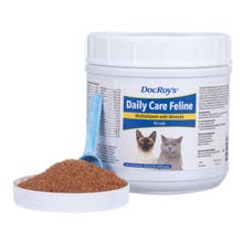 A white container has a label  "DocRoy's Daily Care Feline" with cats on it. The cap has a spoon in a pile of brown powder.